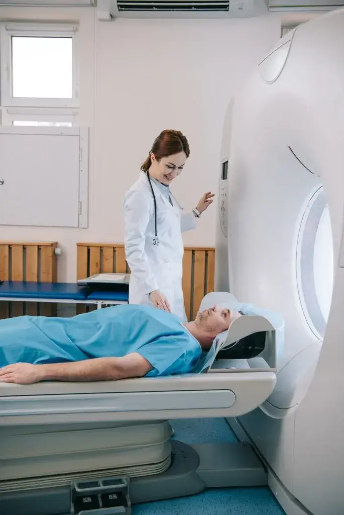 attractive-smiling-doctor-preparing-man-for-scanning-in-mri-machine